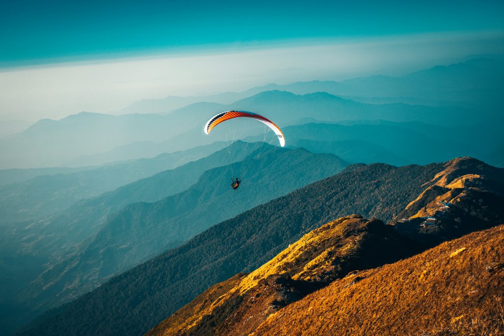 parasailing over the mountains with  beautiful calm blue colors