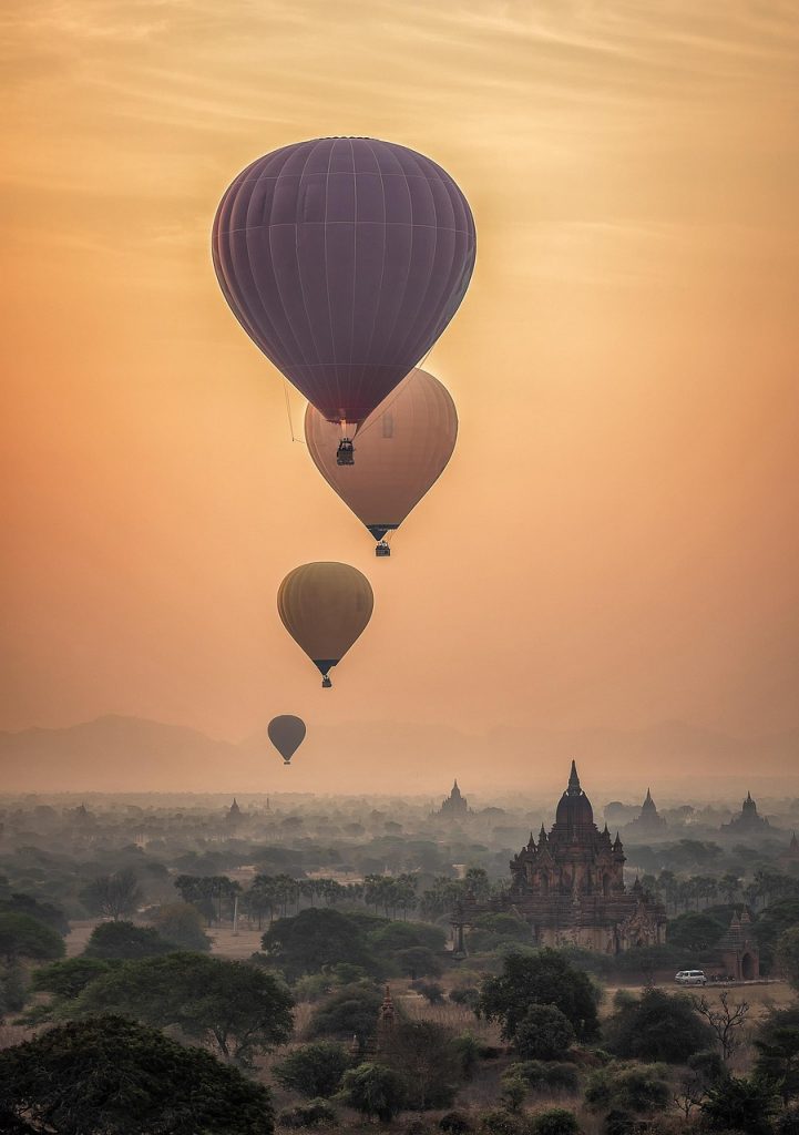 Hot Air Balloon soft colored sky above the clouds you can see peaks of temples.
