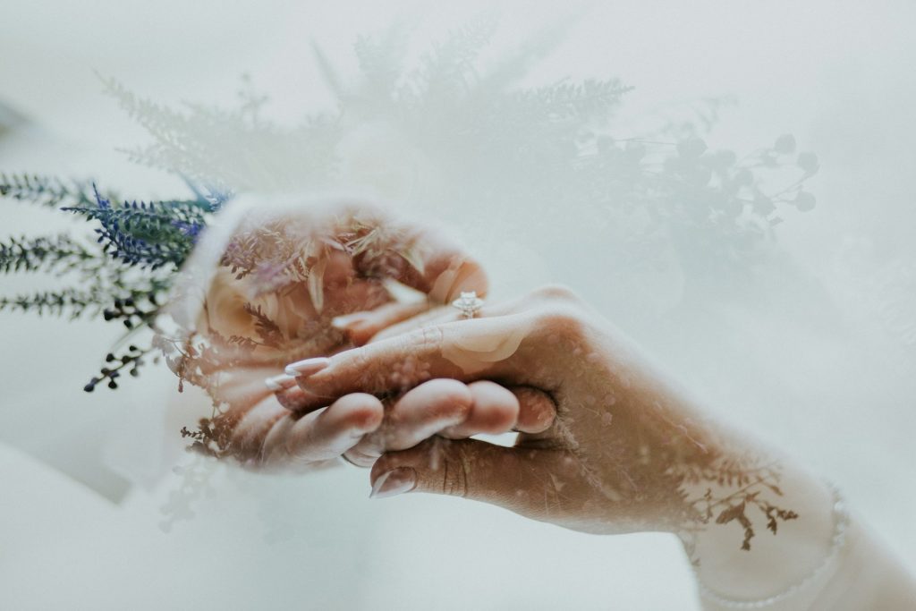 2 hands holding each other in a romantic wedding way